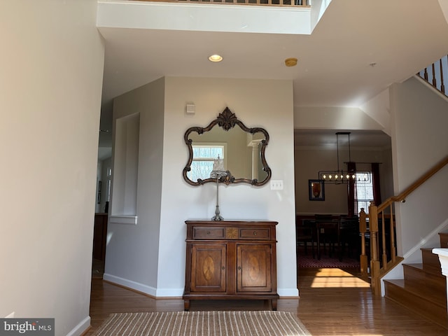 hallway featuring recessed lighting, wood finished floors, baseboards, and stairs