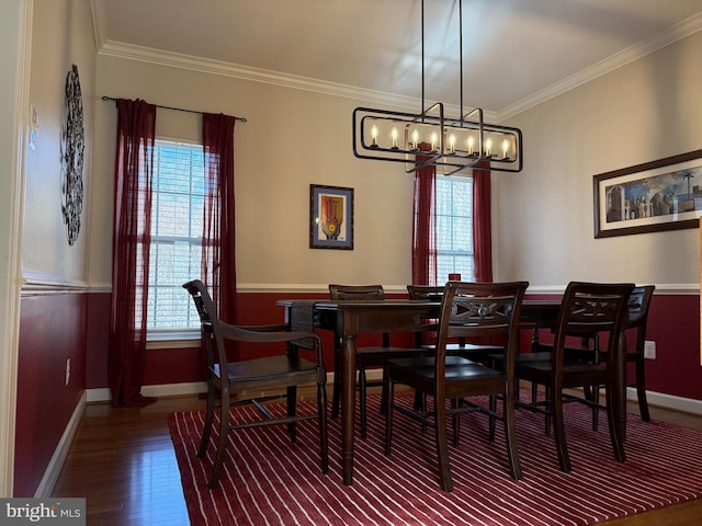 dining room featuring baseboards, a chandelier, wood finished floors, and crown molding