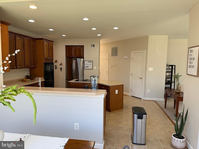 kitchen featuring visible vents, a peninsula, black appliances, and light tile patterned flooring