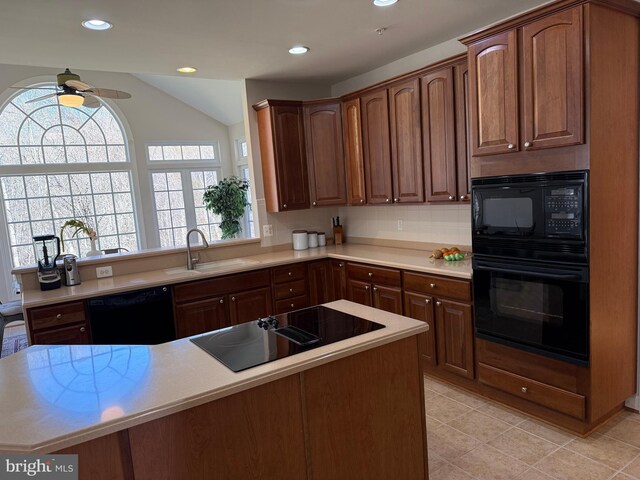 kitchen with ceiling fan, a sink, light countertops, a wealth of natural light, and black appliances