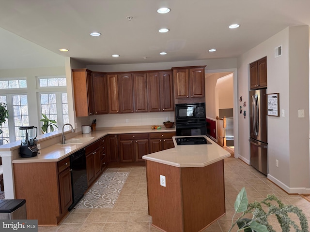 kitchen with light countertops, visible vents, a sink, and black appliances