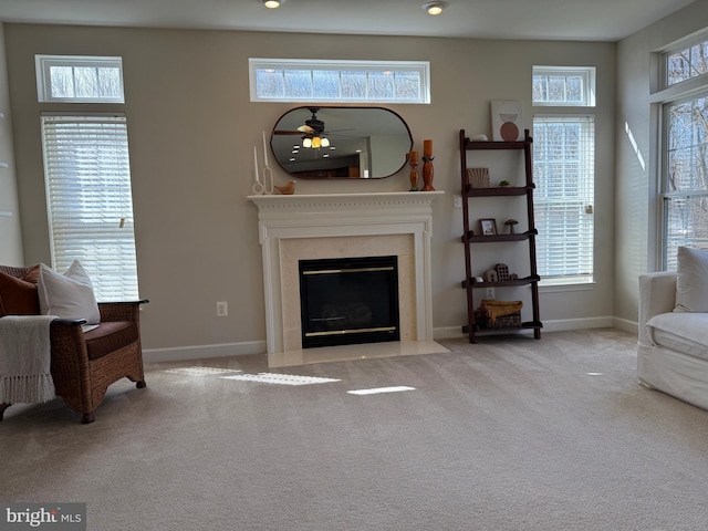 living room featuring carpet floors, a healthy amount of sunlight, and a fireplace with flush hearth