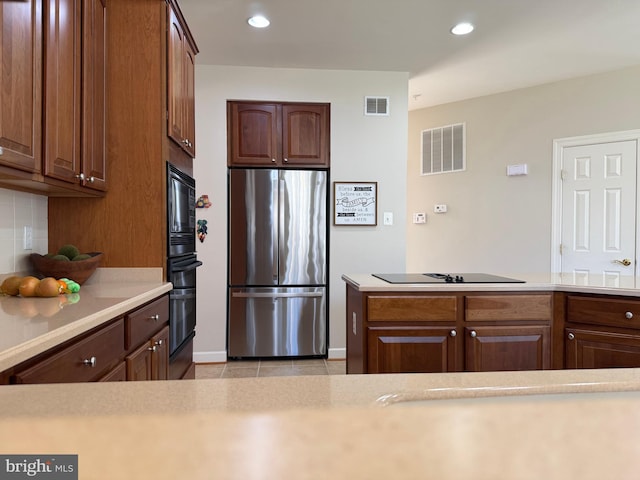 kitchen featuring tasteful backsplash, light countertops, visible vents, and black appliances