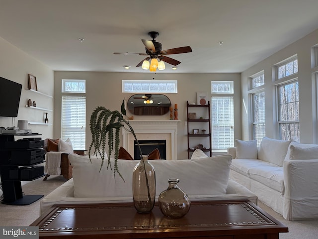 living room featuring ceiling fan, a fireplace, and carpet flooring