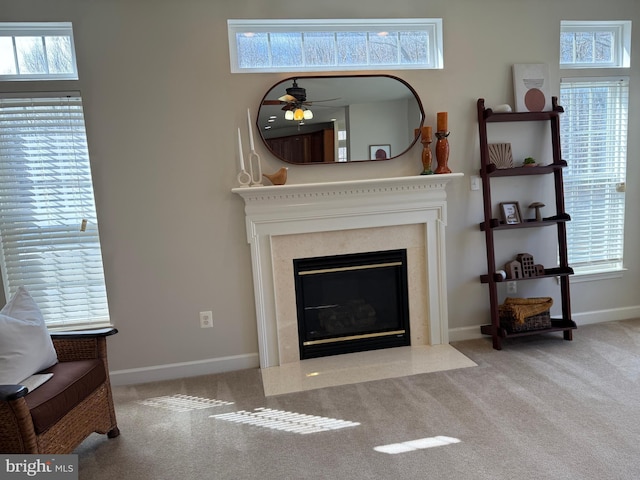 carpeted living area featuring plenty of natural light, a high end fireplace, and baseboards