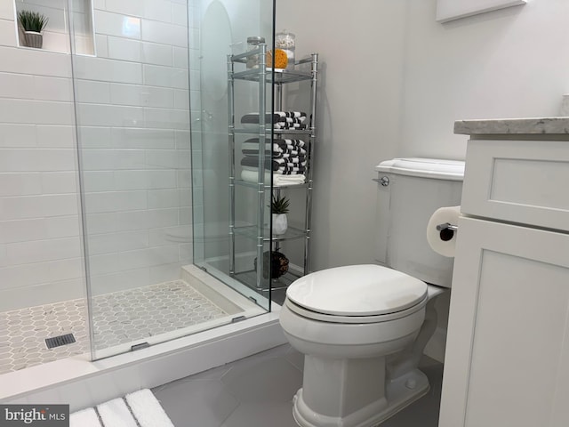 bathroom featuring toilet, tile patterned floors, a shower stall, and vanity