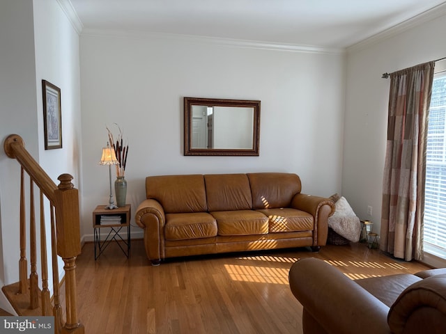 living area with light wood finished floors, stairway, and ornamental molding