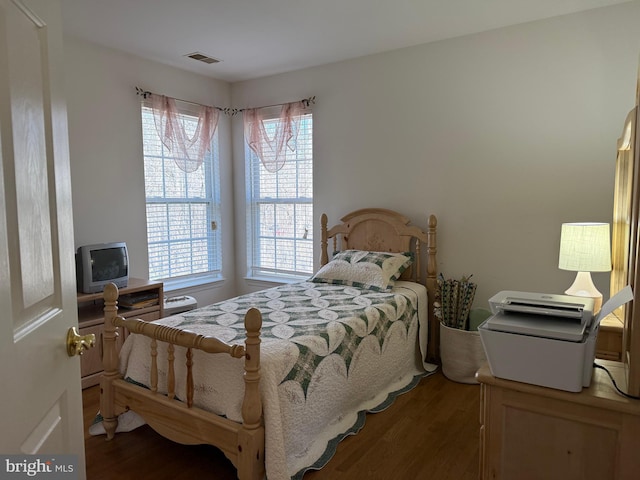 bedroom featuring wood finished floors and visible vents