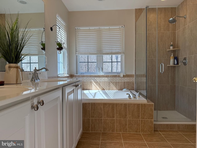 full bathroom featuring vanity, a shower stall, a bath, and a healthy amount of sunlight