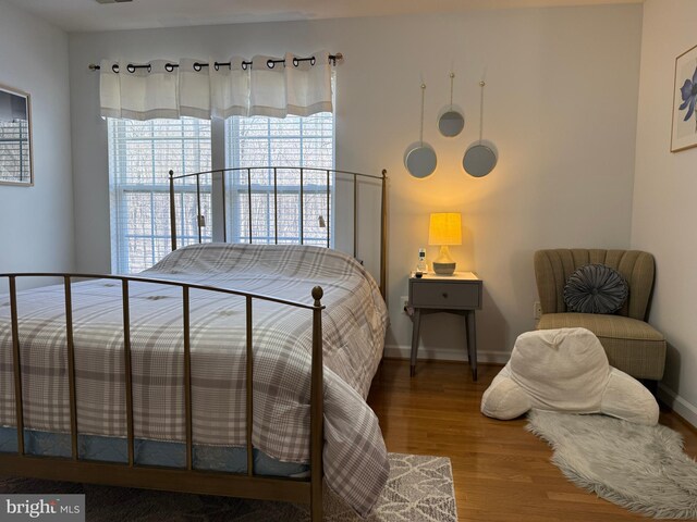 bedroom featuring baseboards and wood finished floors