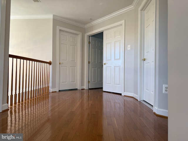 interior space featuring ornamental molding, dark wood-style flooring, and baseboards