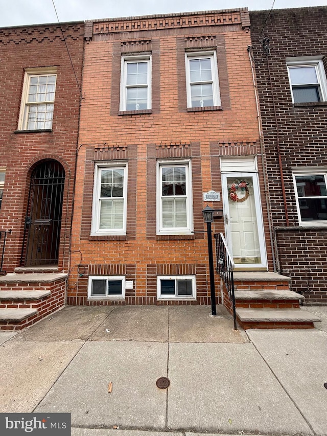 view of property featuring entry steps and brick siding