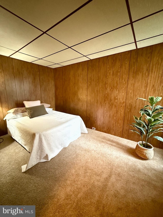 unfurnished bedroom featuring carpet flooring and wooden walls