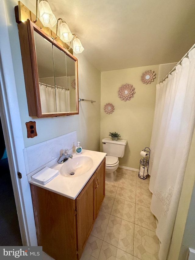 full bathroom featuring toilet, tile patterned flooring, baseboards, and vanity