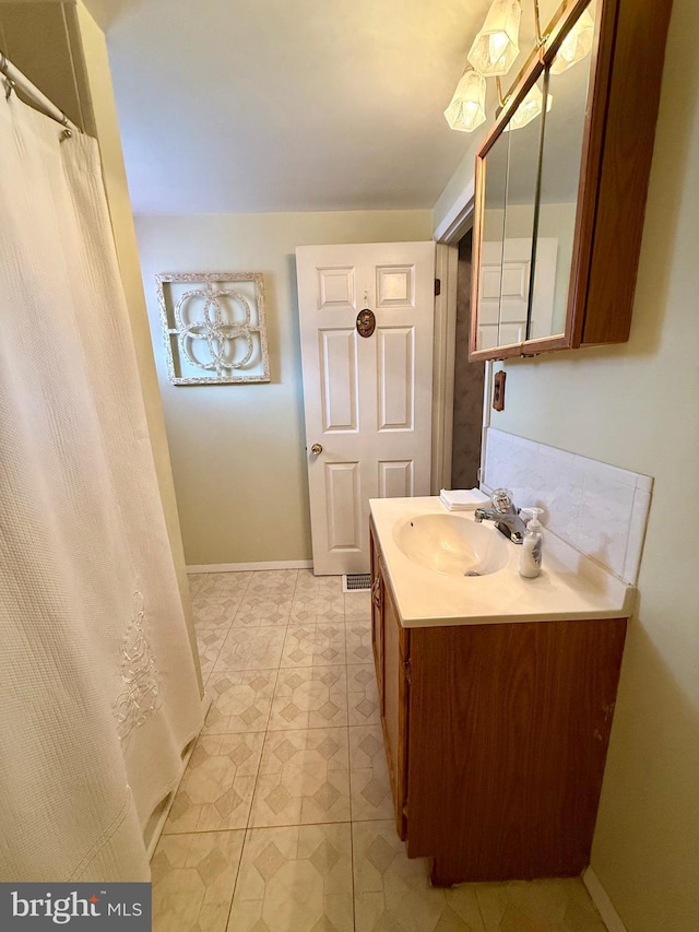 full bathroom with vanity and baseboards