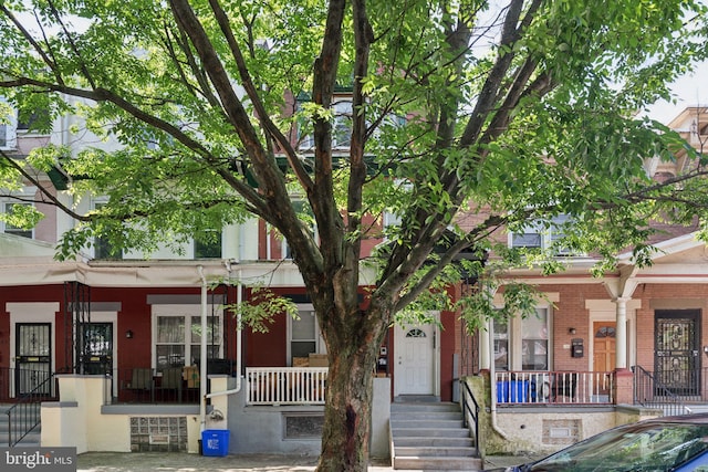 multi unit property featuring a porch and brick siding