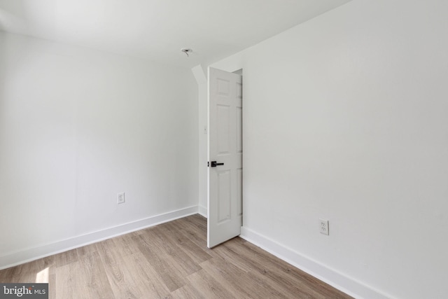 unfurnished room with light wood-type flooring and baseboards