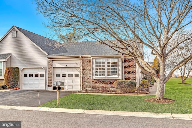 view of front of home featuring brick siding, a front lawn, an attached garage, and aphalt driveway