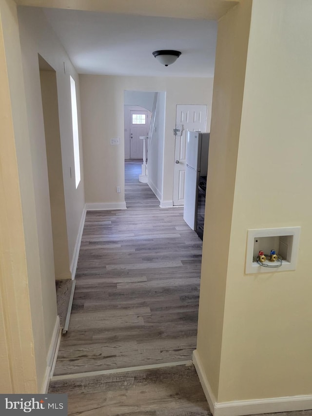 hallway featuring wood finished floors and baseboards