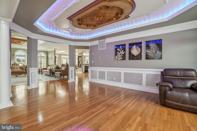 2205 Dhow Ct, Bowie, MD 20721 - living area with ornate columns, a raised ceiling, ornamental molding, light wood-type flooring, and wainscoting