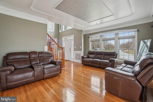 2205 Dhow Ct, Bowie, MD 20721 - living room featuring stairway, light wood-style flooring, healthy amount of natural light, ornamental molding, and a tray ceiling