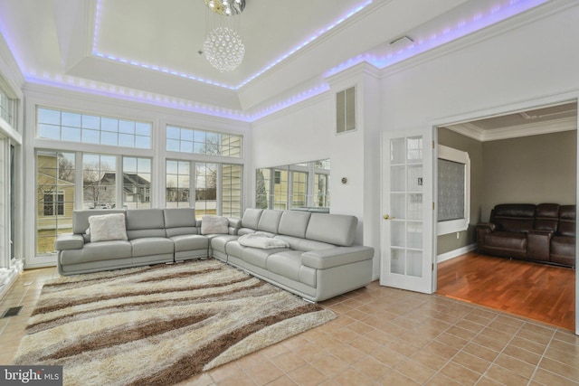 2205 Dhow Ct, Bowie, MD 20721 - living room with light tile patterned floors, crown molding, a towering ceiling, a tray ceiling, and a chandelier
