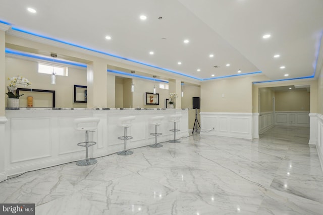2205 Dhow Ct, Bowie, MD 20721 - interior space featuring a decorative wall, a wainscoted wall, a breakfast bar, light marble finish flooring, and recessed lighting