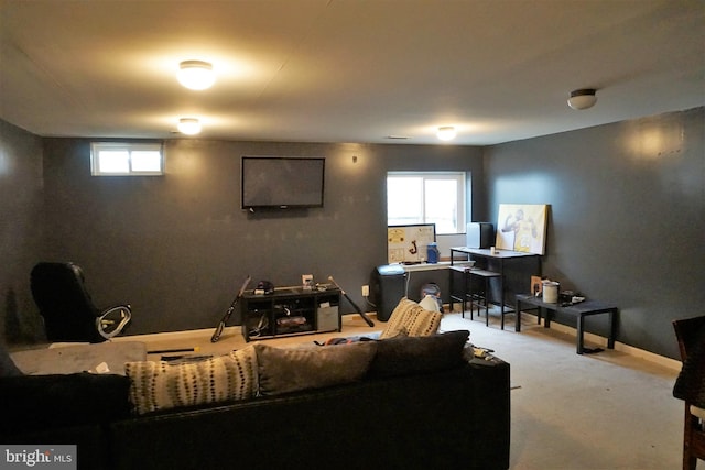 carpeted living area with plenty of natural light and baseboards