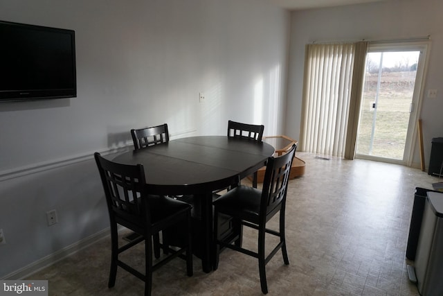 dining space featuring tile patterned floors and baseboards