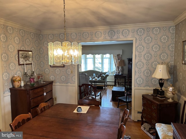 dining area featuring a wainscoted wall, wood finished floors, and wallpapered walls