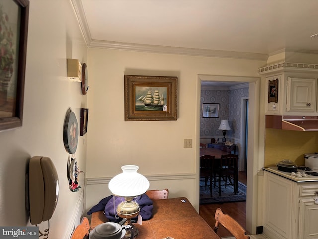 dining area featuring dark wood-type flooring and ornamental molding