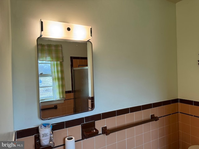 full bath featuring tile walls and a shower with door