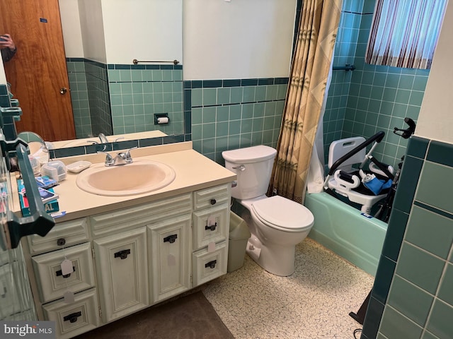 bathroom featuring a wainscoted wall, toilet, tile walls, and shower / tub combo