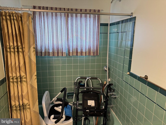 full bath featuring shower / bath combination with curtain, tile walls, and a wainscoted wall