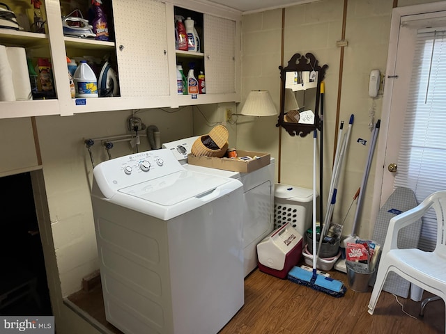 laundry area featuring washing machine and dryer, wood finished floors, and laundry area