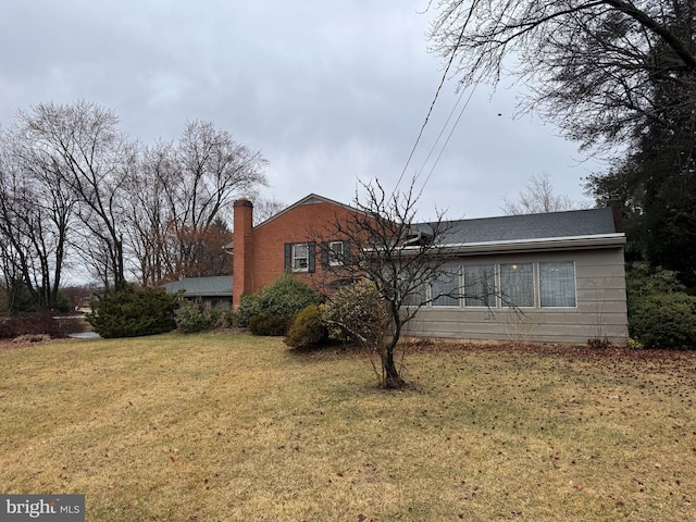 exterior space featuring a chimney and a front lawn