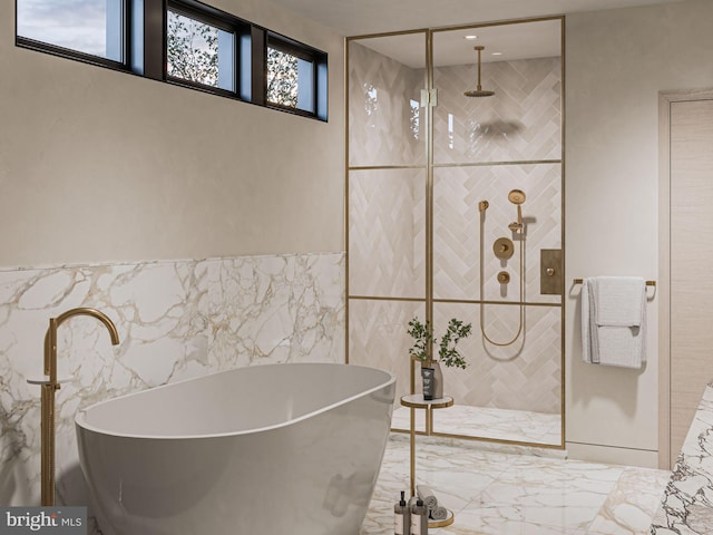 bathroom featuring marble finish floor, tiled shower, and a soaking tub