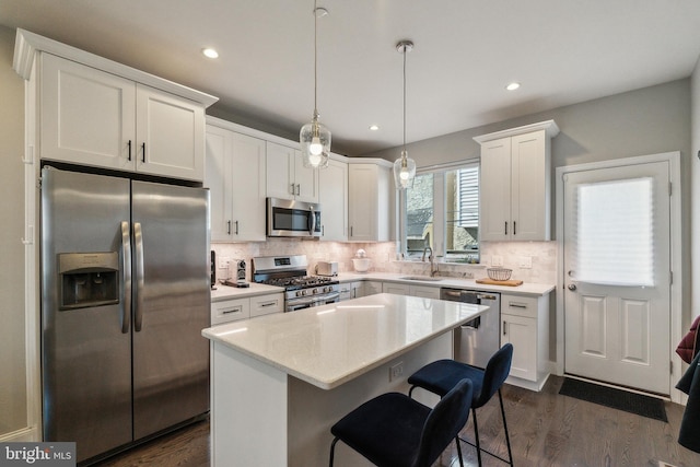 kitchen featuring dark wood-type flooring, backsplash, appliances with stainless steel finishes, and white cabinetry