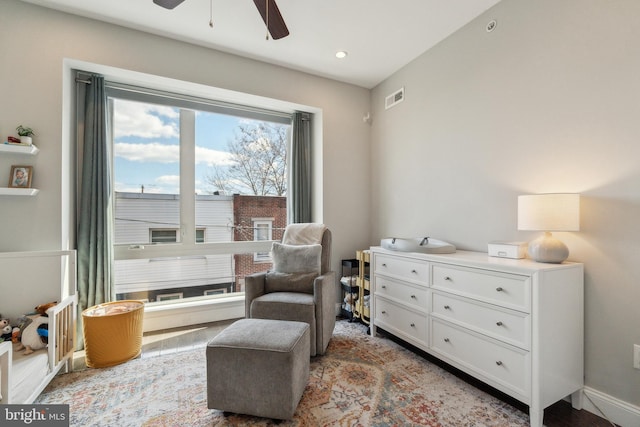 living area with visible vents and ceiling fan