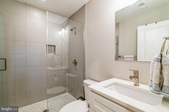 full bathroom featuring vanity, a shower stall, toilet, and visible vents