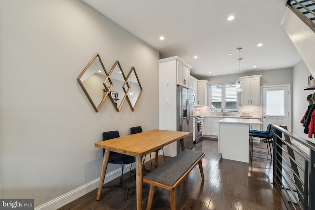 dining room with dark wood finished floors, recessed lighting, and baseboards