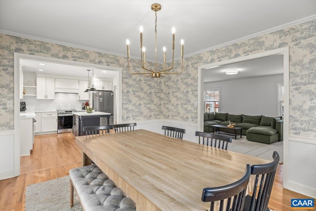 dining area featuring a wainscoted wall, light wood finished floors, and wallpapered walls