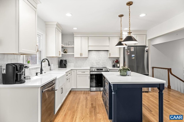 kitchen featuring open shelves, white cabinetry, stainless steel appliances, and a kitchen breakfast bar