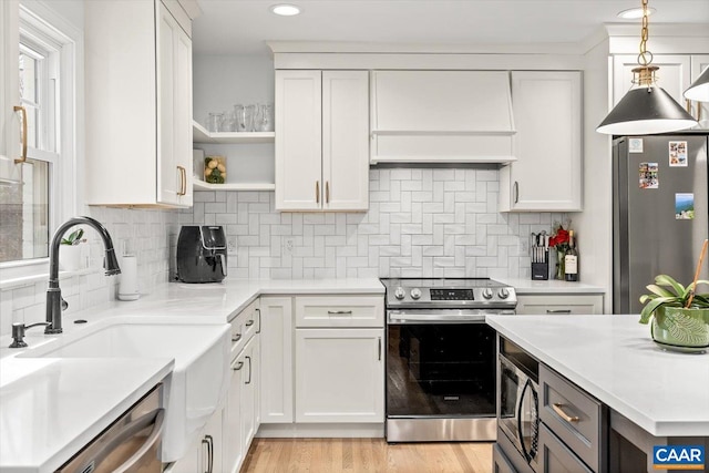 kitchen with stainless steel appliances, open shelves, light countertops, and white cabinets