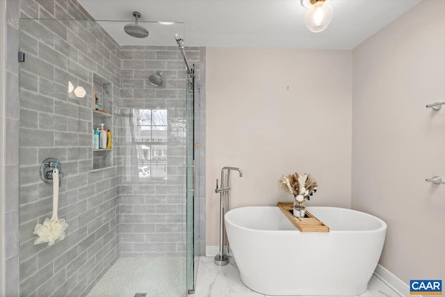 bathroom with marble finish floor, a stall shower, a soaking tub, and baseboards