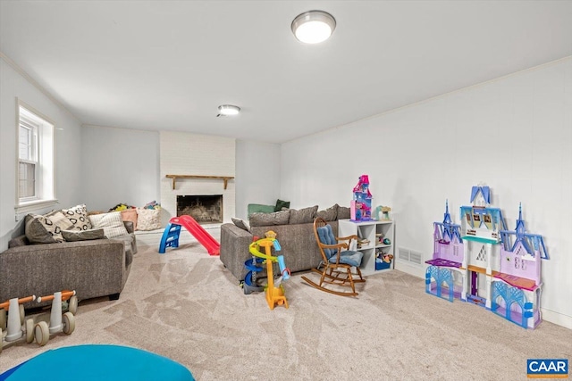 recreation room featuring a brick fireplace, visible vents, and carpet flooring