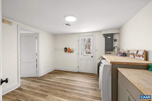 washroom featuring visible vents, light wood-style flooring, laundry area, electric panel, and independent washer and dryer