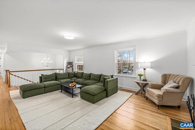 living room featuring a chandelier, plenty of natural light, and light wood-style flooring