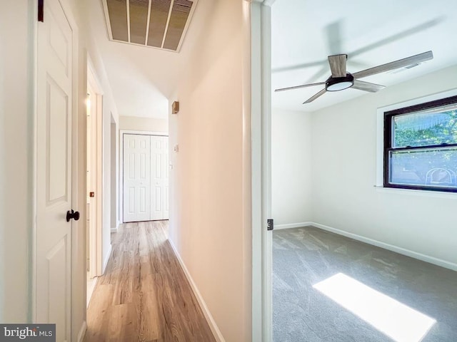 hallway featuring baseboards and visible vents