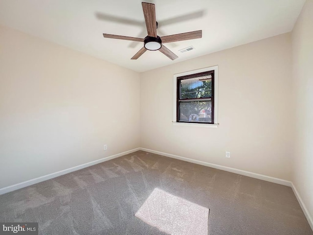 spare room featuring carpet floors, visible vents, baseboards, and a ceiling fan